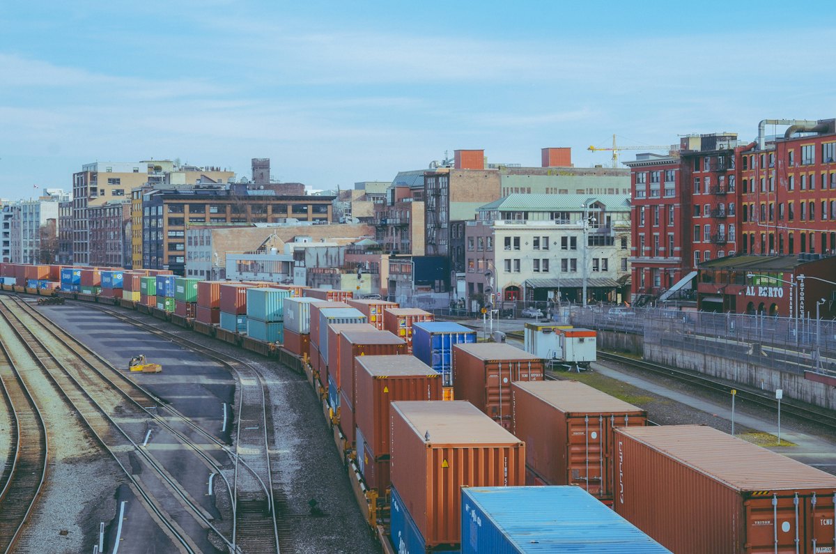 Freight train loaded with shipping containers passing through a city